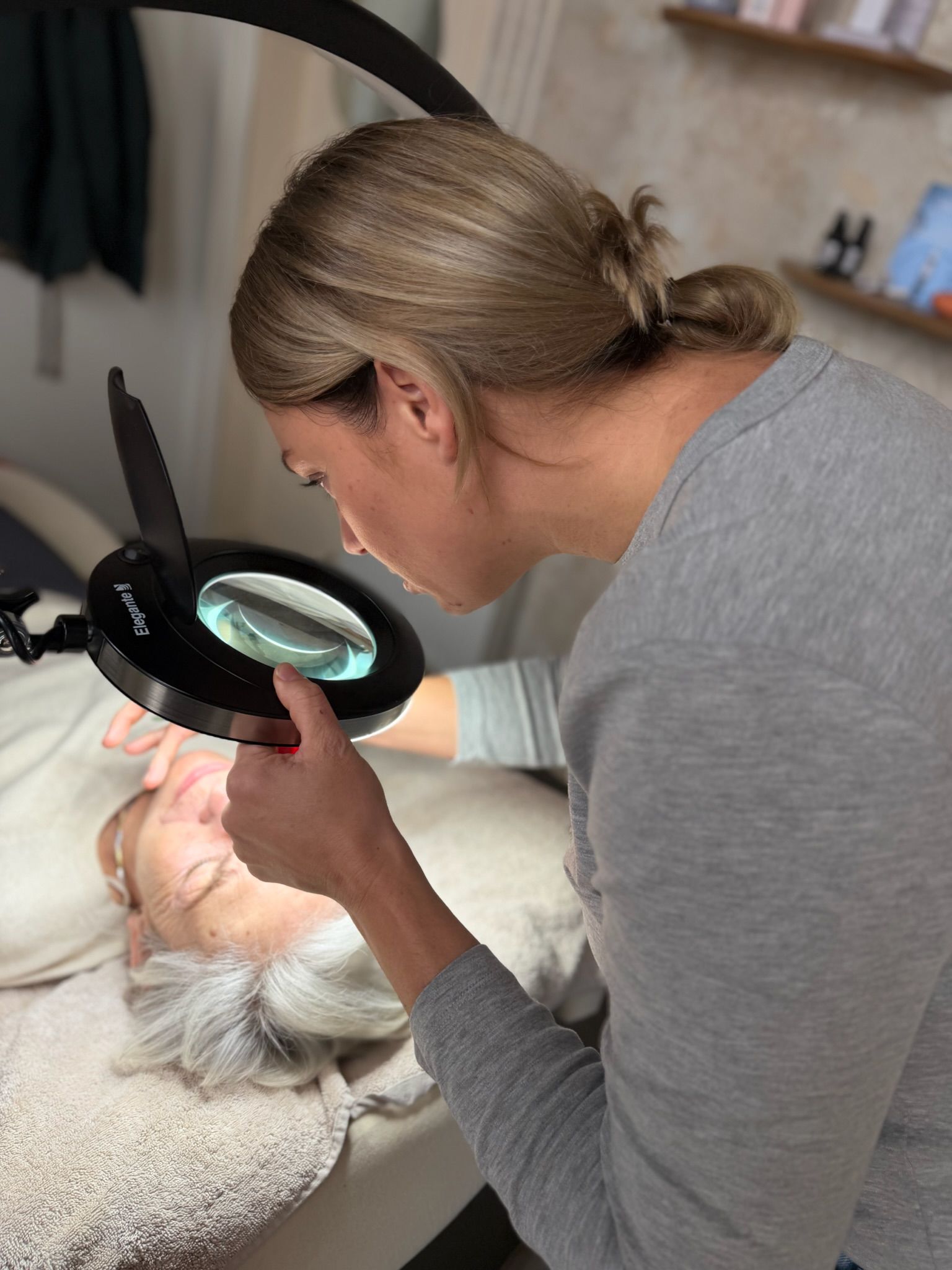 Teamfoto voor de salon 'WINO about skin & hair' waarbij zes lachende medewerkers gezellig samen voor de salon staan, uitgedrukt in hun stijlvolle werkkledij, met een kerstboom die bijdraagt aan de warme, feestelijke sfeer. Dit beeld benadrukt de vriendelijke en hechte sfeer binnen het team.